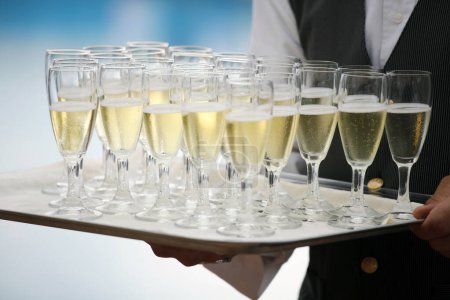 Téléchargez les photos : Champagne dans les verres sur plateau dans les mains, gros plan - en image libre de droit
