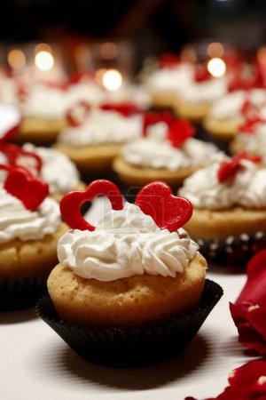 Foto de Un primer plano de un delicioso cupcakes con un corazón rojo en el fondo borroso - Imagen libre de derechos