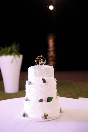 Foto de Pastel de boda con rosas blancas y velas - Imagen libre de derechos