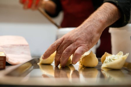 Téléchargez les photos : Mains d'un homme âgé coupe un morceau de fromage avec un couteau - en image libre de droit