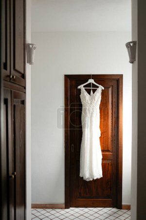 Foto de Vestido de novia colgando de la percha en el dormitorio - Imagen libre de derechos