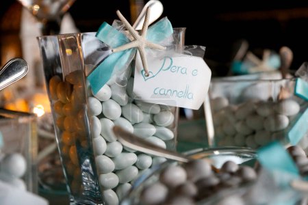 Photo for Table with delicious variegated sugared almonds elegantly displayed, table with candies at wedding reception - Royalty Free Image