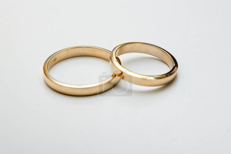 Foto de Dos anillos de boda de oro en una superficie de oro. - Imagen libre de derechos
