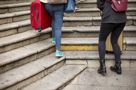 Téléchargez les photos : Deux femmes marchant dans les escaliers avec une valise - en image libre de droit