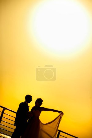 Téléchargez les photos : Silhouette d'une mariée et d'un marié au coucher du soleil - en image libre de droit