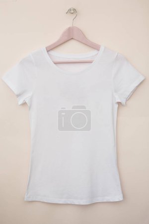 Téléchargez les photos : T-shirt en coton sur cintre sur fond blanc - en image libre de droit
