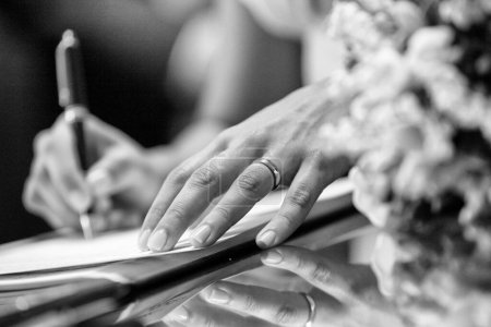 Téléchargez les photos : Mariée signant des documents, fermer dans un noir et blanc - en image libre de droit