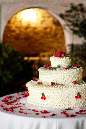 Téléchargez les photos : Gâteau de mariage blanc avec des fleurs rouges - en image libre de droit