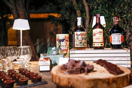 Téléchargez les photos : Boissons alcoolisées en bouteilles et chocolats sur la table - en image libre de droit