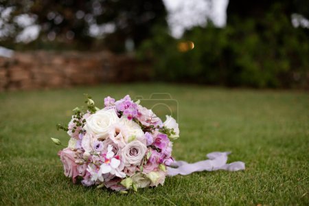 Téléchargez les photos : Bouquet de fleurs roses dans l'herbe dans un mariage - en image libre de droit