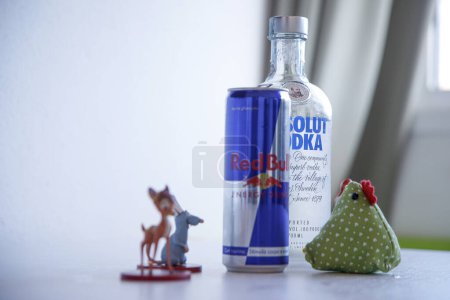 Téléchargez les photos : Bouteille de vodka et bouteille de taureau rouge sur une table blanche - en image libre de droit