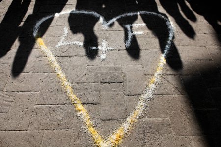 Téléchargez les photos : Graffiti sur une rue, beau coeur sur la chaussée - en image libre de droit