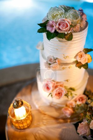 Photo for Beautiful wedding cake with roses and candle - Royalty Free Image