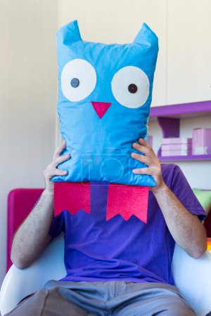 Photo for Man holding cute pillow on his head - Royalty Free Image