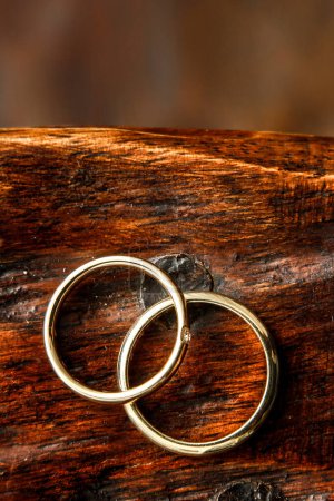Foto de Dos anillos de boda de oro sobre fondo de madera. - Imagen libre de derechos