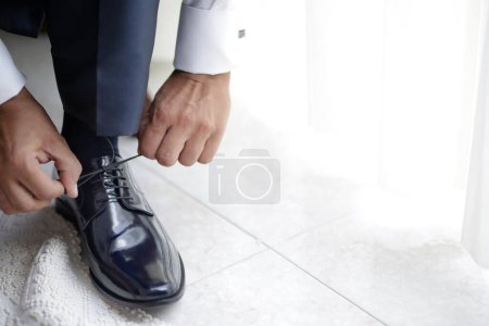 Foto de Primer plano - hasta de hombre de negocios atando zapatos en su habitación - Imagen libre de derechos