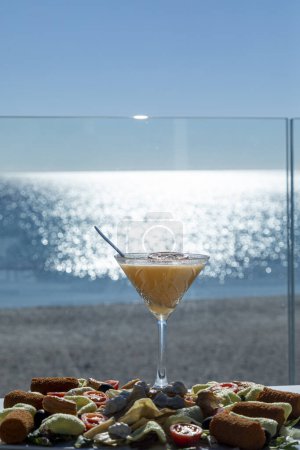 Téléchargez les photos : Un verre de vin orange sur la plage par une journée ensoleillée - en image libre de droit