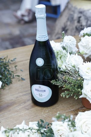 Téléchargez les photos : Bouteille de champagne, bouteille de champagne, roses et champagne sur une table en bois - en image libre de droit