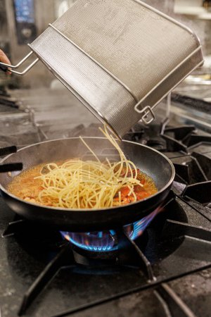 Téléchargez les photos : Cuisson des spaghettis dans la cuisinière - en image libre de droit