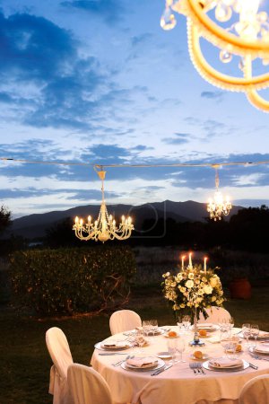 Foto de Hermosa mesa de boda con flores y velas al aire libre - Imagen libre de derechos