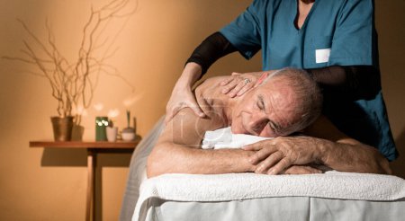 Téléchargez les photos : Vieil homme se faire masser au spa - en image libre de droit