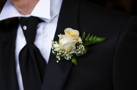 Téléchargez les photos : Gros plan d'un marié en costume avec un arc blanc - en image libre de droit