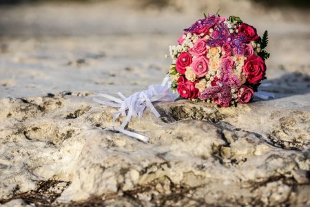 Téléchargez les photos : Bouquet de mariage de fleurs sur le sable de la plage - en image libre de droit