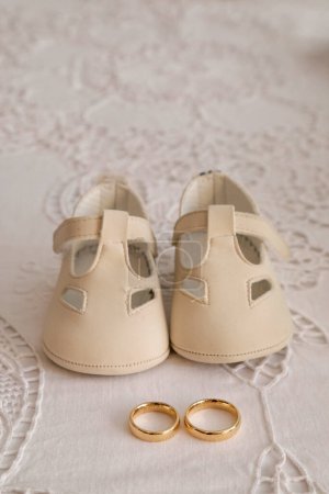 Photo for White baby shoes and wedding rings - Royalty Free Image