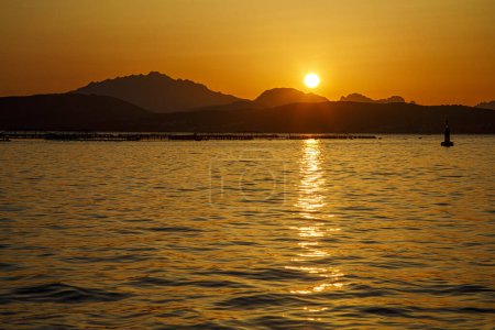 Foto de La puesta de sol sobre el lago con la silueta de un barco. - Imagen libre de derechos