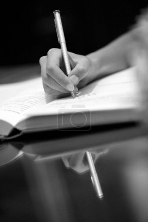 Téléchargez les photos : Mains d'une vieille femme écrivant sur un carnet en noir et blanc - en image libre de droit