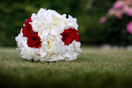 Photo for Red and white wedding bouquet with a white flowers and a green grass - Royalty Free Image