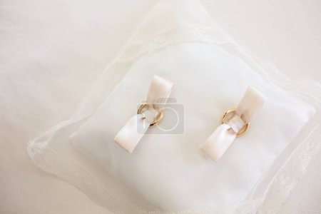 Téléchargez les photos : Anneaux de mariage dorés sur un oreiller - en image libre de droit