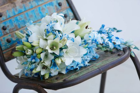 Foto de Ramo de flores azules en una silla sobre un fondo de madera - Imagen libre de derechos
