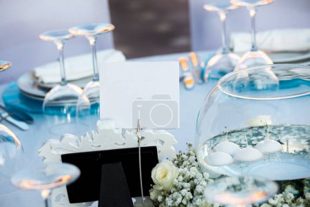 Téléchargez les photos : Décoration de mariage. décor de table avec des fleurs blanches, des bougies et des verres bleus de vin blanc. - en image libre de droit