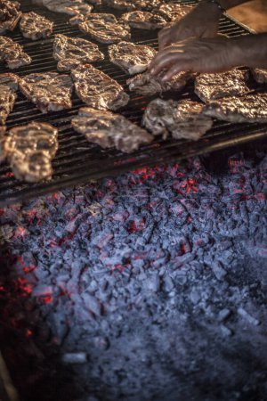 Téléchargez les photos : Plan recadré de la personne cuisson de la viande sur le gril - en image libre de droit