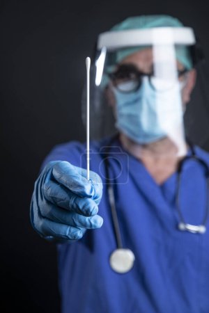 Photo for A doctor in a medical uniform holds a syringe in his hand. - Royalty Free Image