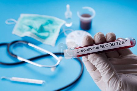 Téléchargez les photos : Éprouvette de sang, thermomètre et autres articles liés au coronavirus, isolée sur fond bleu - en image libre de droit