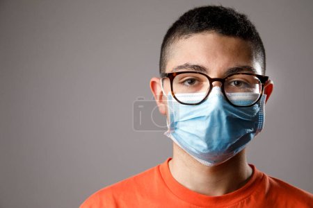 Photo for Portrait of young man wearing protective glasses, against gray background - Royalty Free Image