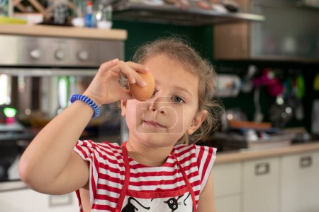 Téléchargez les photos : Mignonne enfant fille dans la cuisine - en image libre de droit