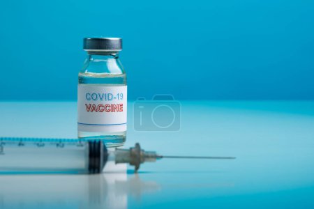 Photo for Coronavirus vaccine bottle in the background the brand of the pharmaceutical company - Royalty Free Image