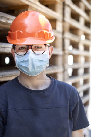 Foto de Retrato del hombre en un casco protector y gafas protectoras en una fábrica - Imagen libre de derechos