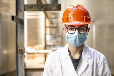 Photo for Male worker wearing helmet and protective mask in the factory. - Royalty Free Image