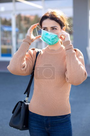 Photo for Girl adjusts her facial mask along the street in an urban context - Royalty Free Image