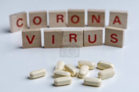 Photo for "crown virus" inscription with wooden letters and loose pads, isolated on white background - Royalty Free Image