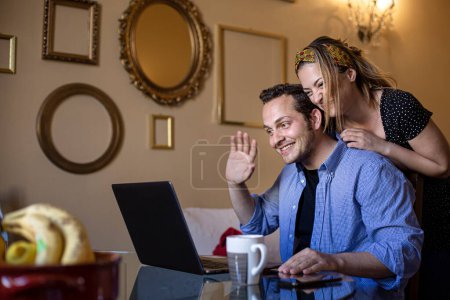 Téléchargez les photos : Couple utilisant un ordinateur portable à l'hôtel - en image libre de droit