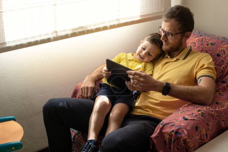 Foto de Padre e hijo con tableta digital en casa - Imagen libre de derechos