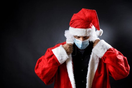 Téléchargez les photos : Portrait du Père Noël sérieux et inquiet, isolé sur fond noir - en image libre de droit