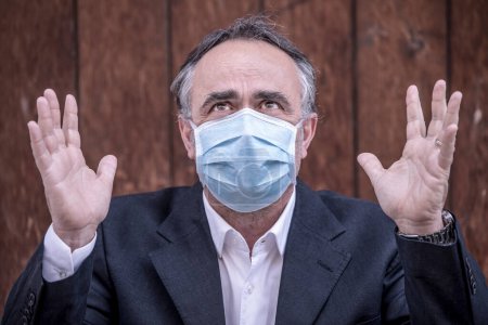 Photo for Man dressed in suit with protective face mask in urban context - Royalty Free Image