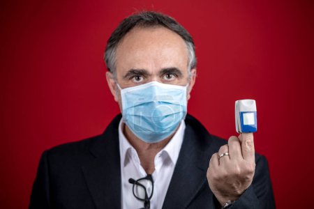 Téléchargez les photos : Portrait d'un homme portant un masque chirurgical isolé sur fond - en image libre de droit