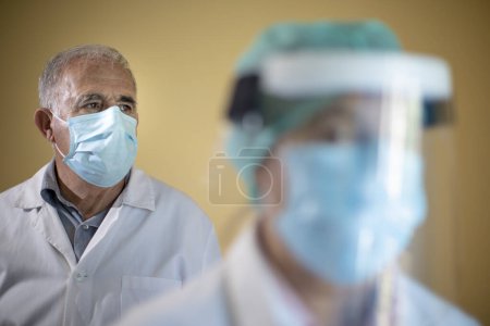 Téléchargez les photos : Médecin et assistant avec masques - en image libre de droit